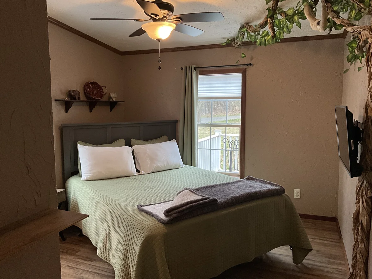 Bedroom at The Auburn with a made bed and warm lighting