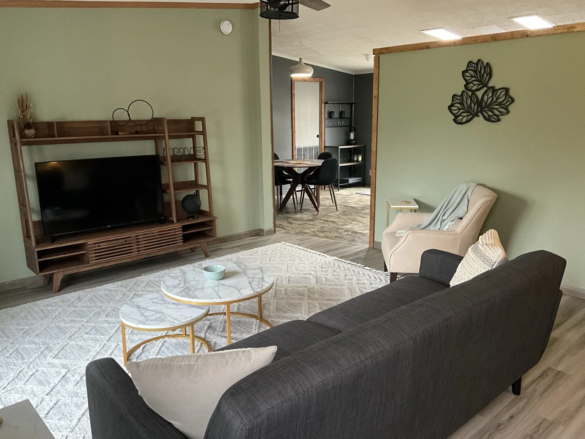 The Auburn living room with sofa, coffee table, and TV